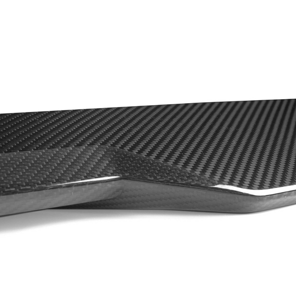 Carbon fiber panel with a textured, glossy surface, lies flat and neatly angled. The background is a plain, white setting, emphasizing the panel’s sleek and modern design.