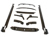 Car body kit components arranged on a white background, including aerodynamic parts like side skirts, bumpers, and wing pieces, all sleek and glossy, designed for vehicle customization.