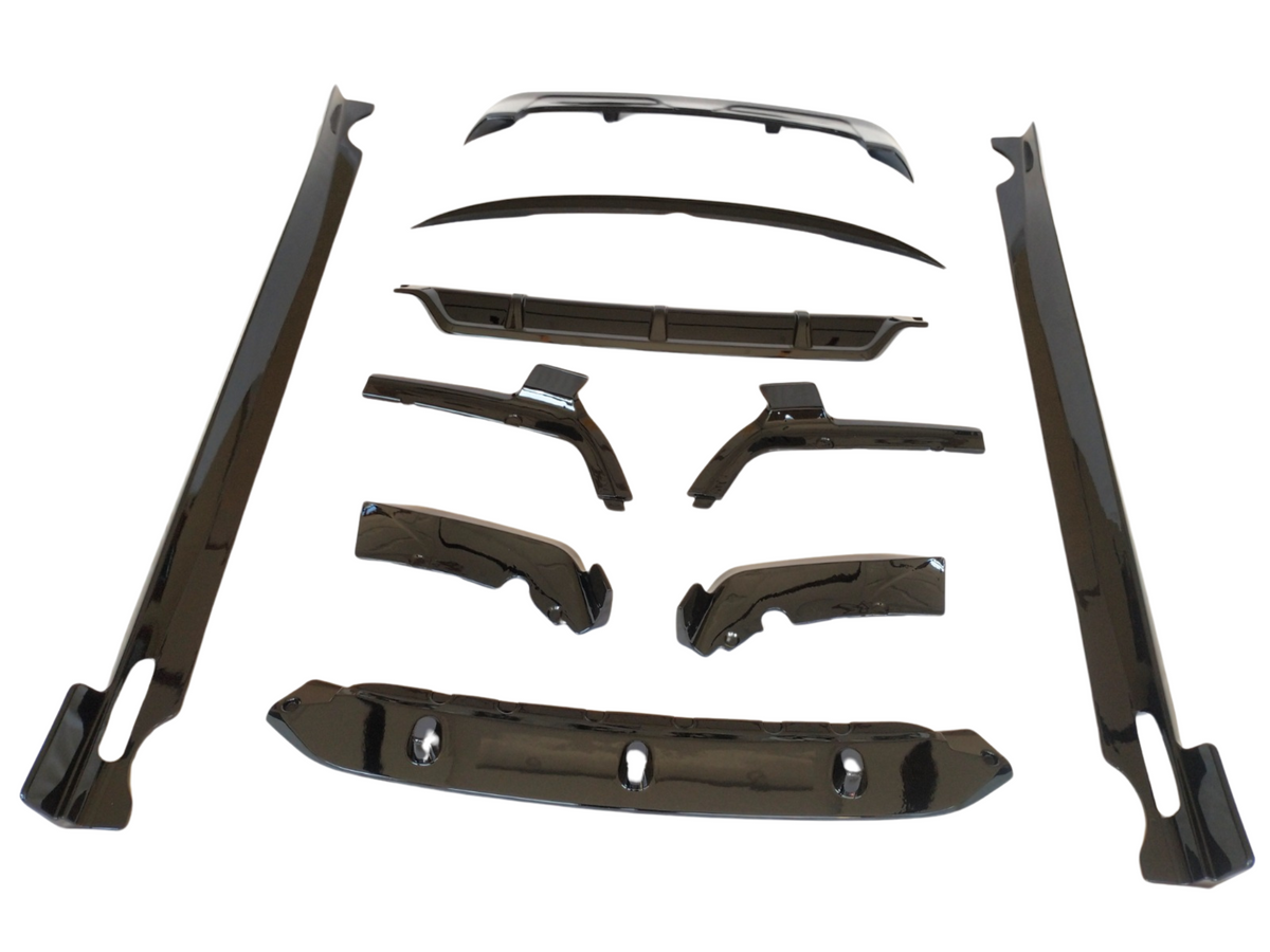Car body kit components arranged on a white background, including aerodynamic parts like side skirts, bumpers, and wing pieces, all sleek and glossy, designed for vehicle customization.