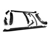 Various carbon fiber car parts lie scattered on a white surface, including spoilers and side skirts, arranged in an orderly fashion, highlighting their sleek, aerodynamic design.