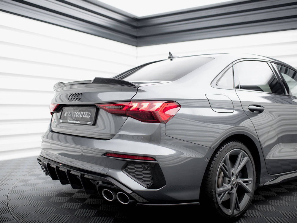 A sleek silver car is parked in a modern showroom. The backplate reads "#MAYTONIZED Paweł Świątek." The vehicle features distinctive taillights and dual exhaust pipes.