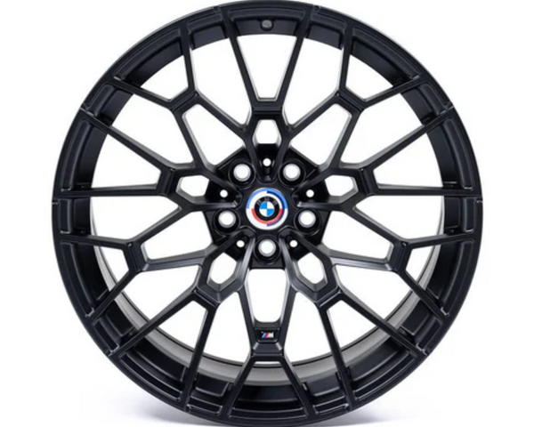 A black alloy wheel with a complex geometric spoke design features a BMW emblem at the center. It rests on a plain white background.