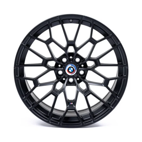 A black alloy wheel with a complex geometric spoke design features a BMW emblem at the center. It rests on a plain white background.