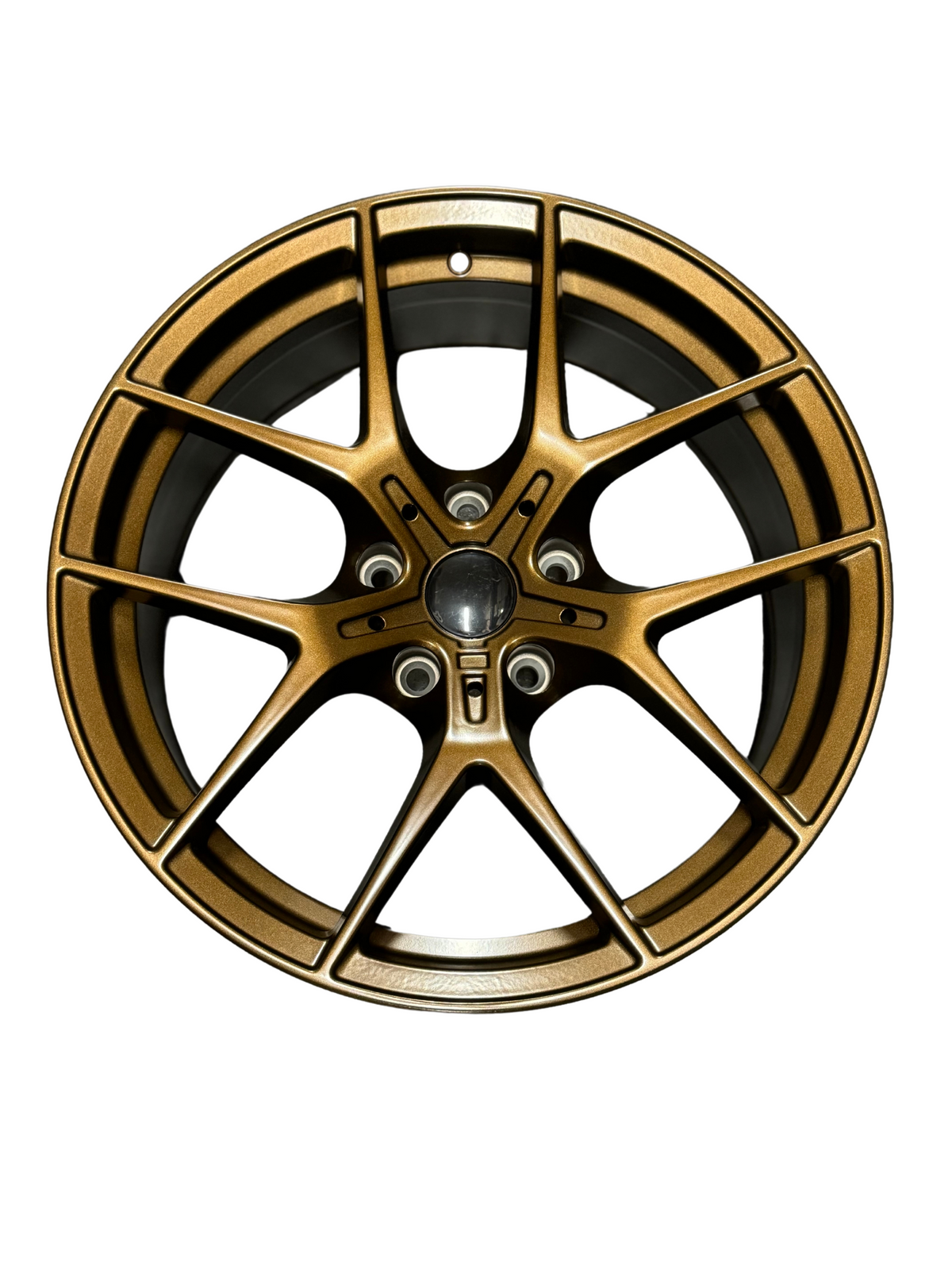 A bronze alloy car wheel with five spokes, centered in a plain white background, displaying a sleek design and circular bolt pattern.