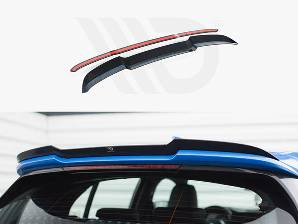Rear vehicle spoiler, positioned on a blue car, enhances aerodynamics. The upper section shows the spoiler design with a red accent, highlighting its sleek shape. Indoor garage setting.