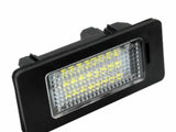 A rectangular LED light with a black frame and clear lens, displaying multiple yellow light diodes, lies at an angle on a plain white background.