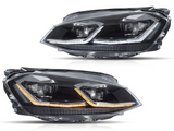 Two sleek car headlights are shown with LED accents; one displays white and the other orange lights. They are placed against a plain white background.