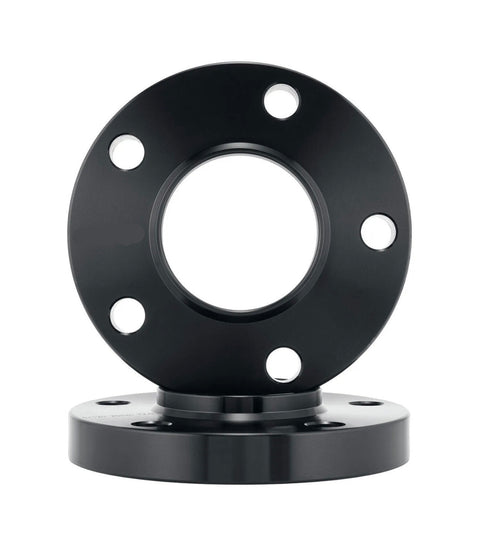 Black metal flange with a circular shape, featuring four evenly spaced bolt holes, rests vertically on another identical flange. The background is plain white, highlighting the object.