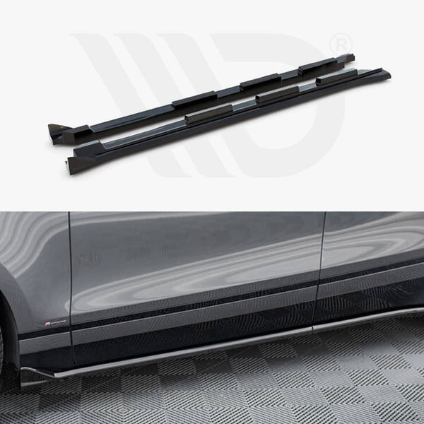 Two black side skirts are displayed above a partial view of a gray car parked on a patterned floor. The side skirts are aligned with the car's lower edge.