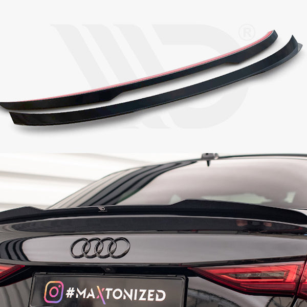 Two black car spoilers sit on a plain background above a black Audi with one spoiler installed on the trunk. License plate reads: "#MAXTONIZED".
