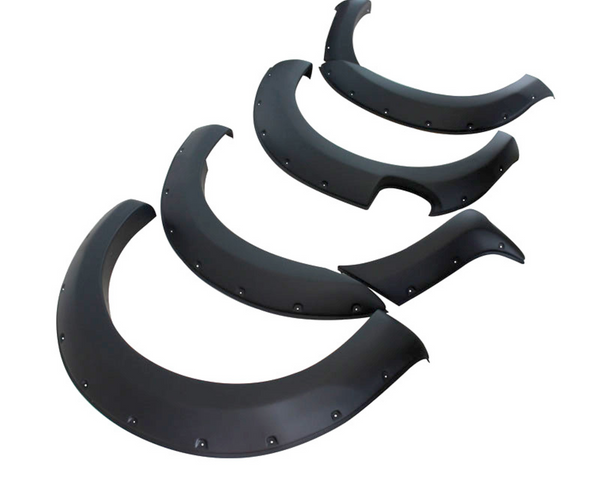 Four black fender flares are arranged on a white background, displaying segments with bolt details and smooth curves, typically used for automotive customization and protection.