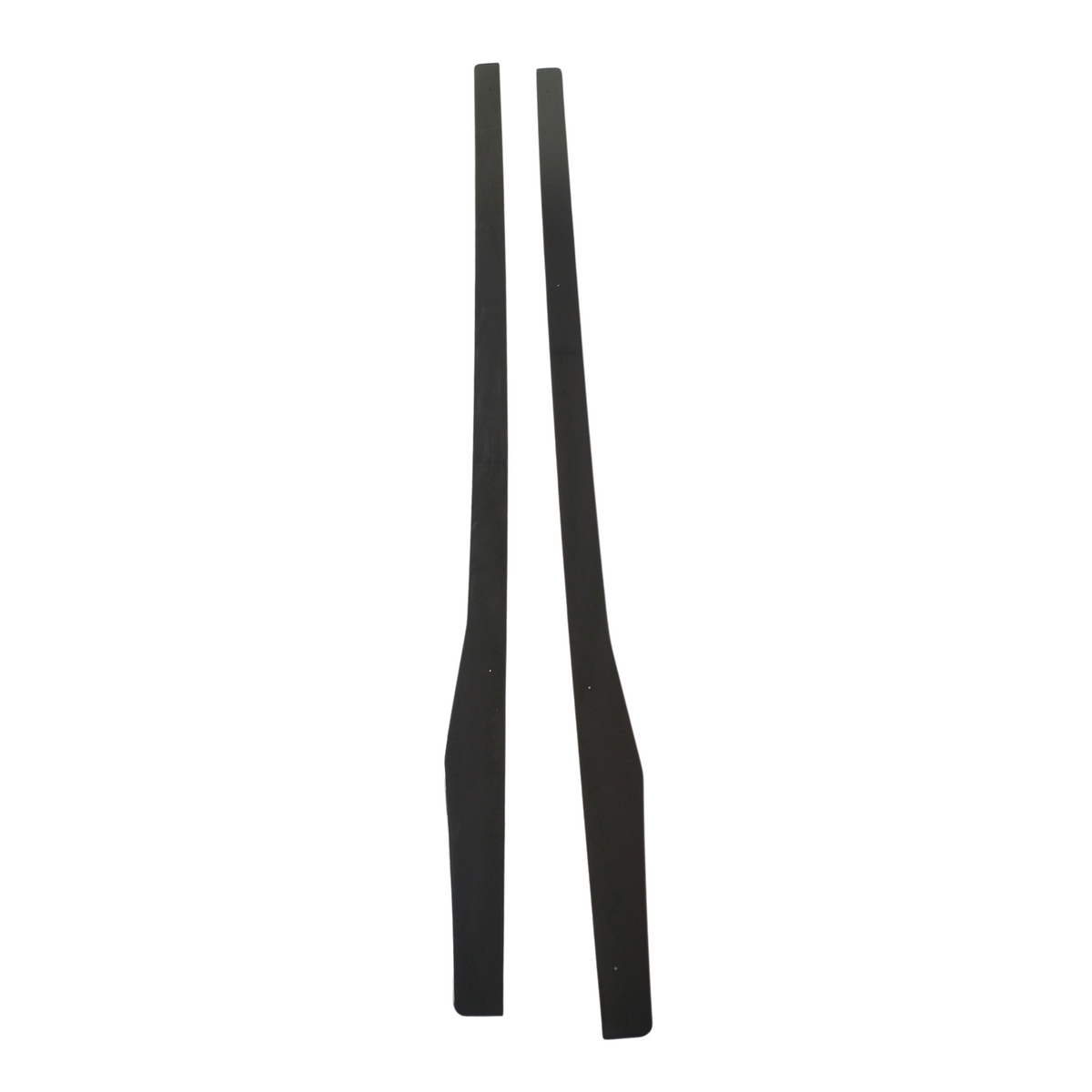 Two black, elongated wooden pieces are standing vertically side by side against a plain white background. They are symmetrical and have tapered ends.