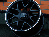 A black alloy wheel with a Mercedes emblem and 