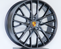 A dark metallic alloy wheel with multiple spokes and a central emblem featuring the Porsche logo, displayed on a platform against a plain white background.