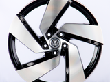 A metallic car wheel with a five-spoke design featuring a central logo; it rests against a plain white background.