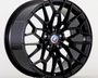 A black alloy wheel showcases a geometric, multi-spoke design, prominently featuring a BMW logo at its center against a plain, light gray background.
