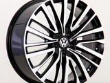 A black and silver alloy car wheel features a sleek, multi-spoke design with a Volkswagen logo at the center, positioned on a plain white background.