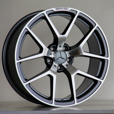 A Mercedes-Benz alloy wheel stands upright, featuring a five-spoke design with a polished finish. The AMG logo is inscribed at the top. It's set against a neutral background.