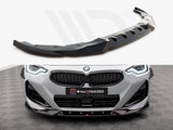 A black car splitter is displayed; the action is showcasing its design. Below, it's installed on a grey BMW, enhancing the front in a showroom with patterned flooring. Text: 