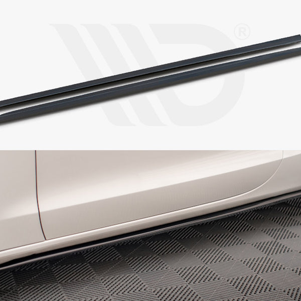 Two long, narrow black side skirt extensions displayed above the side profile of a white car. The car is parked on a textured floor, enhancing its sporty appearance.