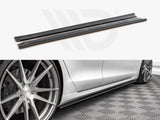 Two black side skirt extensions shown in detail above a photo of a silver car with them installed, positioned next to stylish alloy wheels on a patterned floor.
