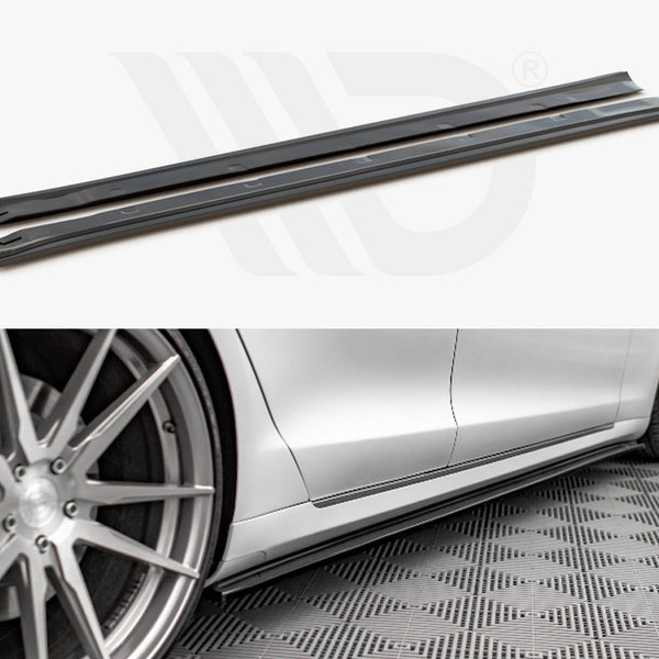 Two black side skirt extensions shown in detail above a photo of a silver car with them installed, positioned next to stylish alloy wheels on a patterned floor.