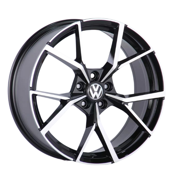 A black and silver alloy wheel with a geometric spoke design is displayed, featuring a central emblem with "VW." The wheel is positioned against a plain white background.