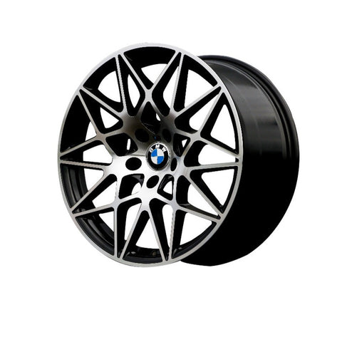 A sleek, intricate multi-spoke BMW car wheel with a central blue and white logo is displayed against a plain white background, emphasizing its geometric design and smooth finish.