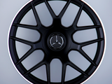 A black alloy wheel with a Mercedes emblem and 