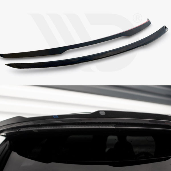 Two black spoilers are displayed; one is installed above a car's rear window in a garage-like setting with white walls.