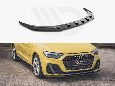 Spoiler: A black, angular car spoiler with triangular cutouts is displayed. It is installed on a yellow car with a hexagonal grille parked on a concrete surface. "MAXTON" branding visible.