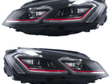 Two black vehicle headlights, each featuring sleek LED designs with red accents, are shown against a white background.