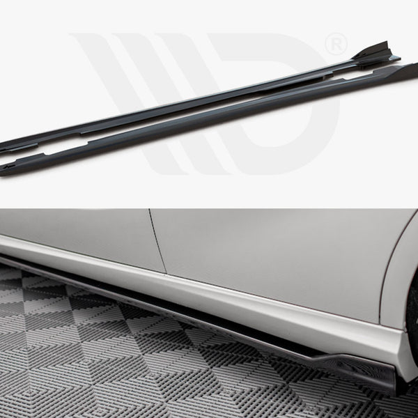 Two black side skirts are displayed individually and attached to the side of a silver car, enhancing its appearance on a checkered garage floor.