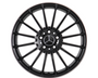 A black alloy wheel with multiple spokes featuring a central emblem resembling interlocking triangles; it is isolated on a white background, showcasing its symmetrical design.
