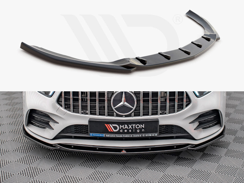 A black car front splitter is displayed; it enhances the aerodynamics of a white Mercedes-Benz with a prominent grille. A sign reads “Maxton design” on the bumper.