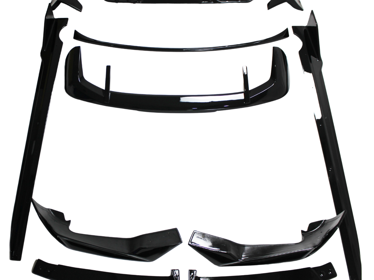 Black car body kit components, including spoilers and side skirts, are arranged on a white background. The parts are neatly organized, showcasing their glossy finish and aerodynamic design.