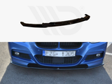 A black front lip spoiler is shown in a manufacturer's display above, then installed on a blue car's front bumper, enhancing aerodynamics while parked on asphalt.