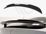 A black car spoiler is mounted on the rear of a white vehicle, enhancing aerodynamics. The upper image shows the standalone spoiler on a white background with a logo.