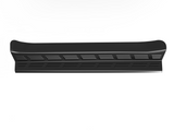 A long, black, rectangular automotive running board with a textured surface and slotted design sits against a plain white background.