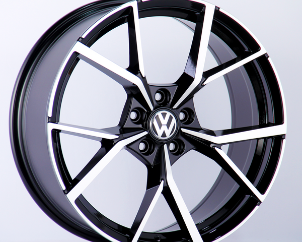 A black and silver alloy wheel is displayed upright. The wheel features the Volkswagen logo in the center, set against a plain white background.