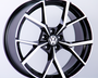 A black and silver alloy wheel is displayed upright. The wheel features the Volkswagen logo in the center, set against a plain white background.
