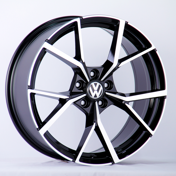 A black and silver alloy wheel is displayed upright. The wheel features the Volkswagen logo in the center, set against a plain white background.