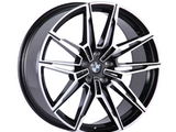 A black and silver alloy wheel features a multi-spoke design with sharp angles and the BMW logo in the center, set against a plain white background.