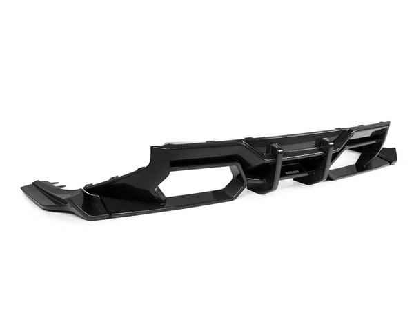 A sleek, black automotive diffuser with angular openings rests on a plain white background, highlighting its futuristic design and glossy carbon fiber texture.