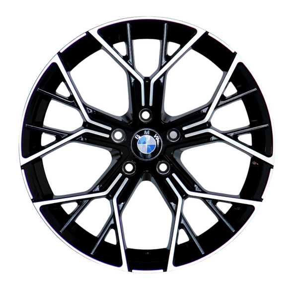 A black alloy wheel with intricate silver spokes and a central BMW logo, resting against a white background.