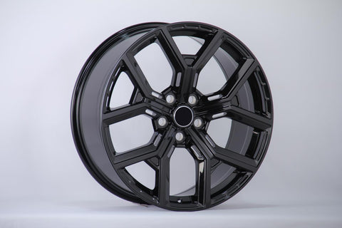 A glossy black alloy wheel with a multi-spoke design is displayed upright against a plain white background, showcasing its smooth and polished surface.