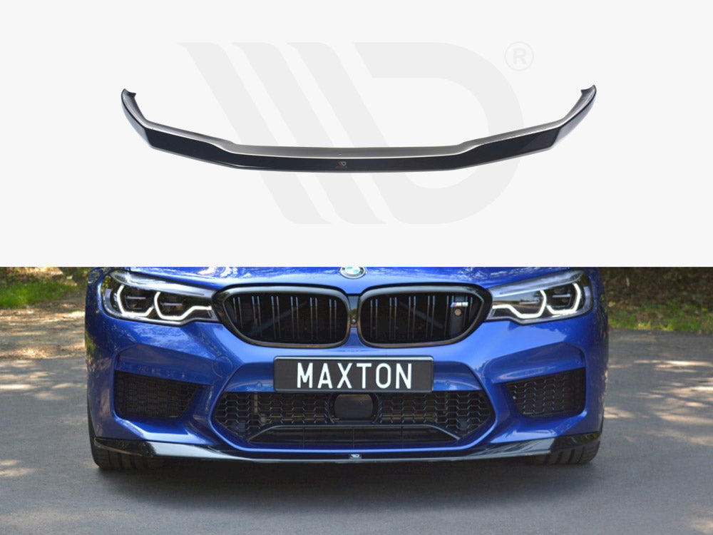 A black car front lip spoiler displayed above a blue car with a distinctive grille and headlights. The car, parked on a road, has a license plate reading "MAXTON."