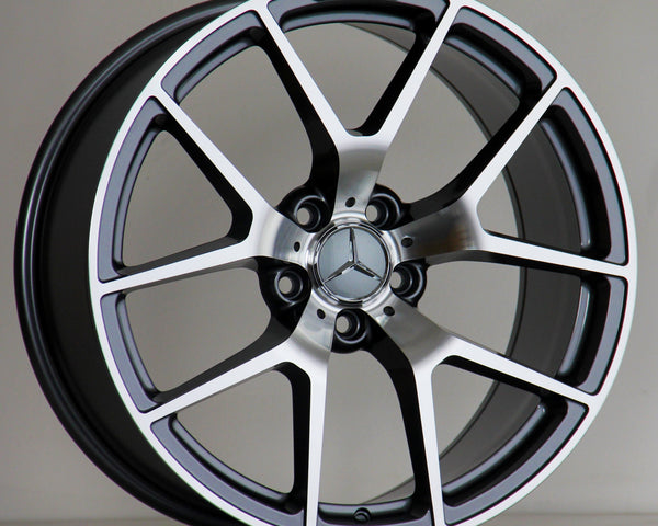 A silver and black Mercedes-Benz AMG alloy wheel rests upright against a neutral background, featuring a five-twin-spoke design and prominent Mercedes emblem at the center.