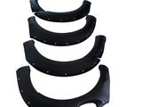 Four black fender flares, lined with rivets, are arranged in descending size order on a plain white background.