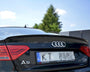 The rear of a black Audi A5 displays its logo and taillights, parked outdoors. Plate text reads: "Kuro Detailing Kompleksowa Pielęgnacja Samochodu." Trees and a fence are visible.